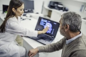 Female doctor of Asian descent showing her patient his brain scan
