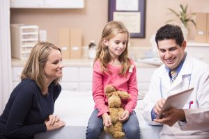 Latin descent doctor with little girl patient and mother